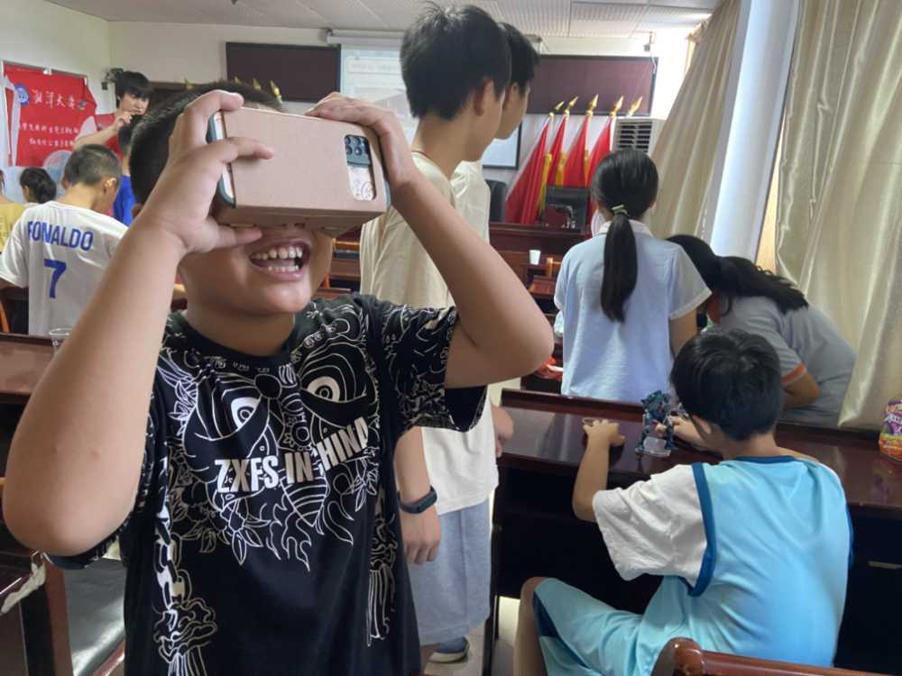 图为小朋友展示自己的VR眼镜制作成果