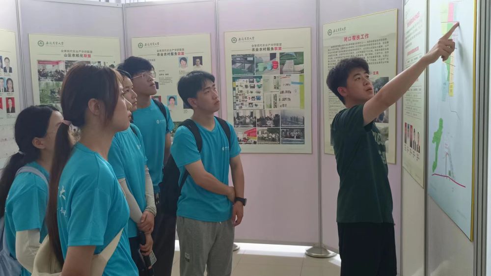 试验站余老师正在带领实践团成员参观大厅展板