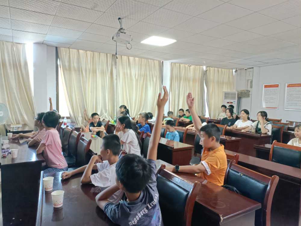 图为积极举手回答小老师问题的小朋友们