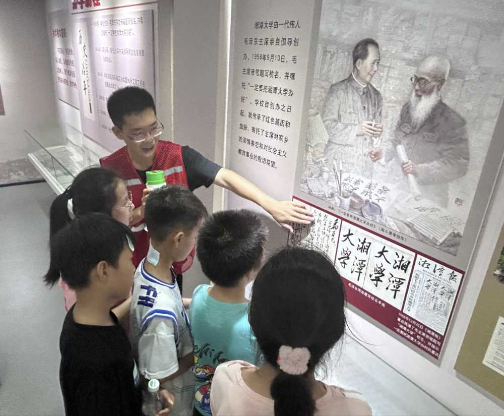 图为红旗村学子认真倾听校史馆讲解