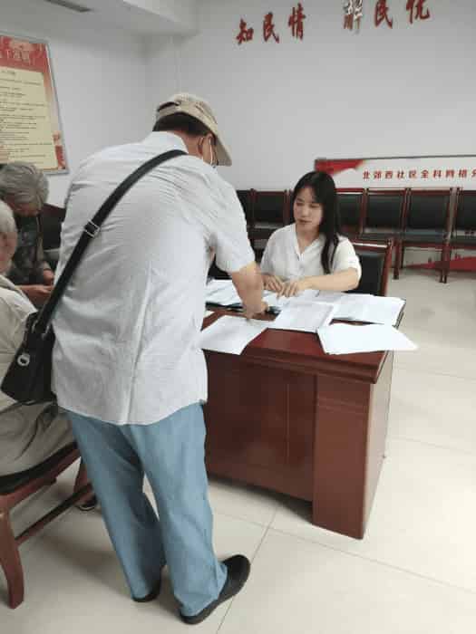 (图为康锦琦同学在为前来办理优待证的退役军人登记)